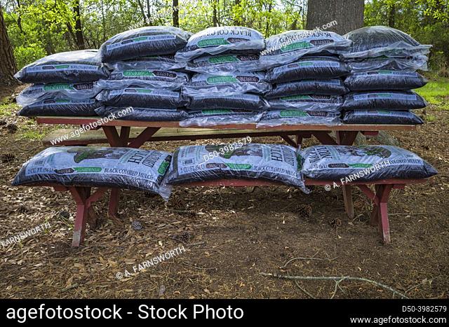 Maryland, USA Bags of mulch sitting on a picnic table in a garden