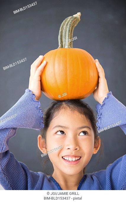 Vietnamese girl balancing pumpkin on head