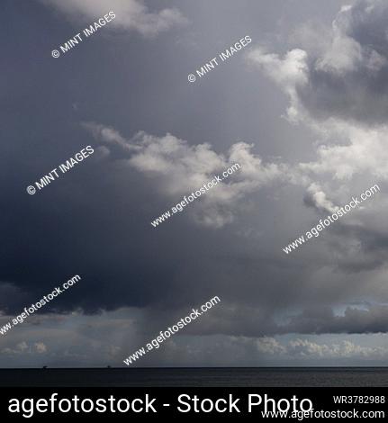 Cloudy dark sky above flat rural landscape