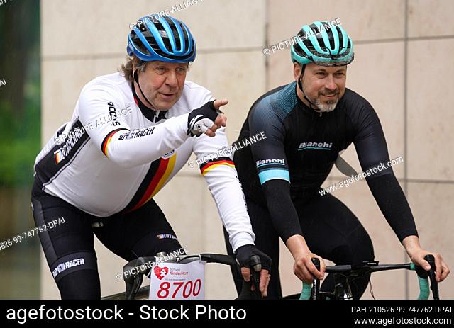 26 May 2021, Hamburg: Actor Uwe Rohde (l) and former professional cyclist Björn Schröder ride their racing bikes to the ""HerzRadtour"" fundraiser for the...