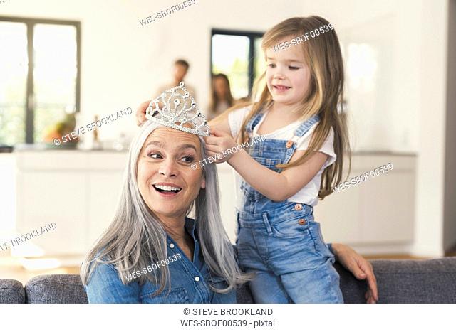 Granddaughter putting crown on grandmothes head