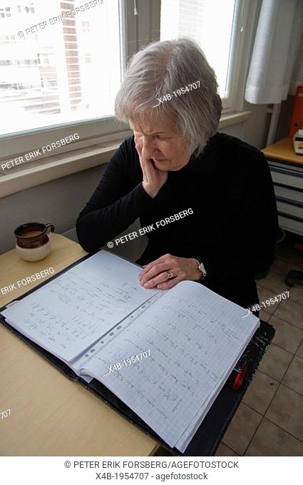 Female in her early 70s doing paperwork Pori Finland Europe