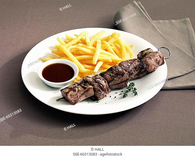 Beef and thyme skewer, chips and small bowl of sauce