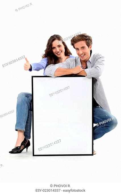 Couple crouching by empty frame