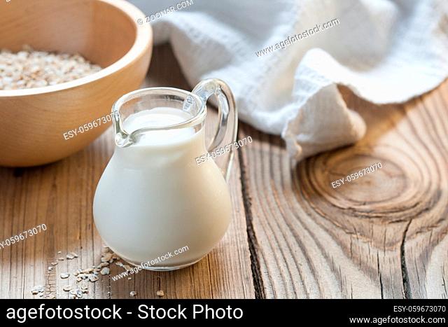 A small jug of milk on wooden background