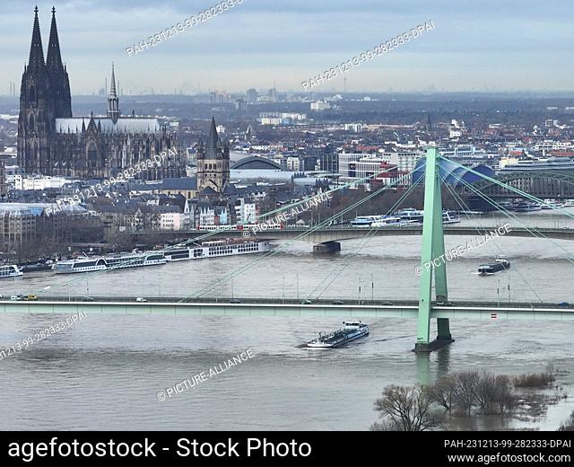 13 December 2023, North Rhine-Westphalia, Cologne: The Rhine in Cologne is flooding. (Aerial photo taken with a drone). The rise in Rhine water levels after...