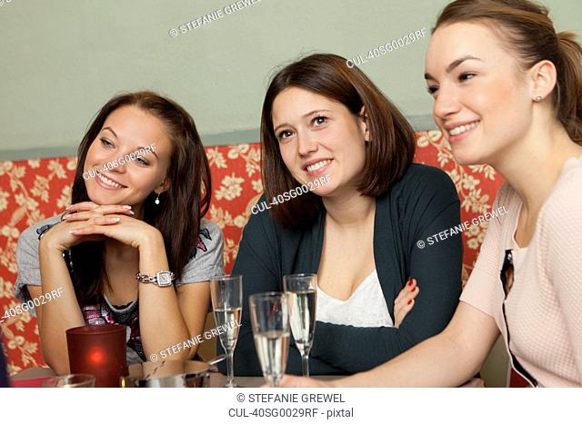 Smiling women having champagne in cafe