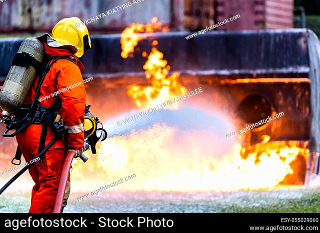 Firefighter using Chemical foam fire extinguisher to fighting with the fire flame from oil tanker truck accident. Firefighter safety disaster accident and...