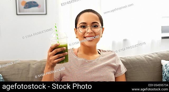 african american woman drinking smoothie at home