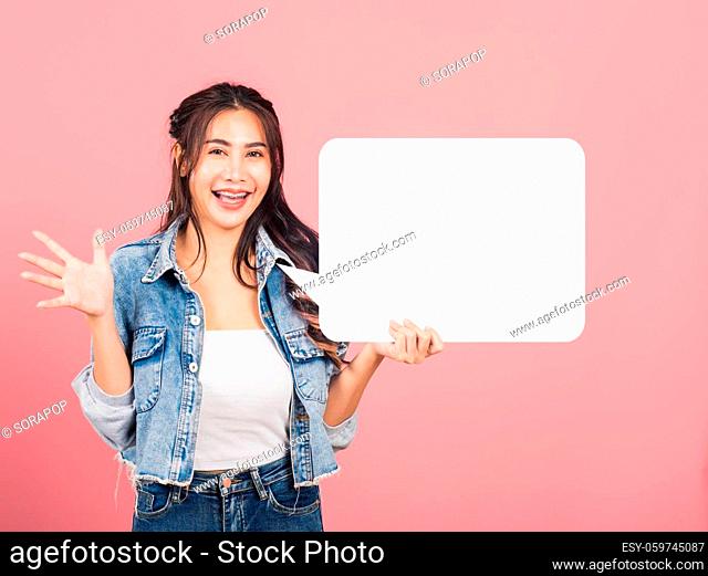 Happy Asian beautiful young woman smiling excited wear denims holding empty speech bubble sign, Portrait female posing show up for your idea looking at camera
