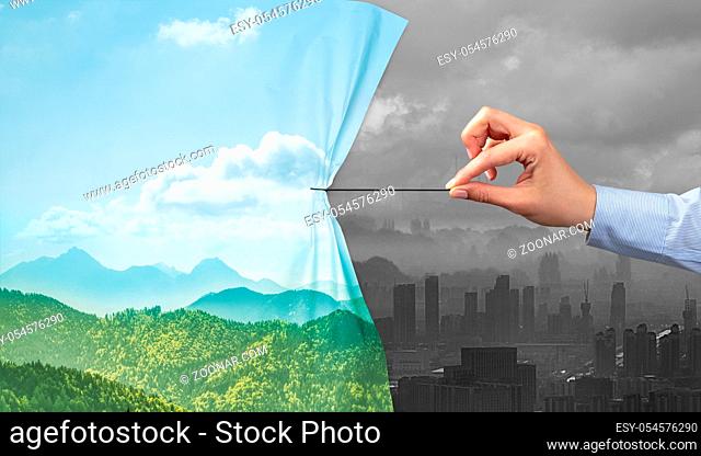 hand pulling nature cityscape curtain to gray cityscape, environmental protection concept