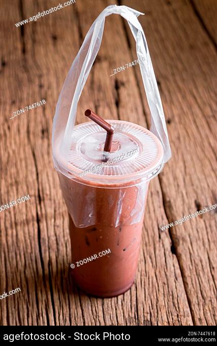 iced cocoa in takeaway cup on wooden table background