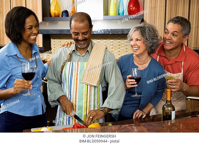 Multi-ethnic friends drinking wine and preparing food
