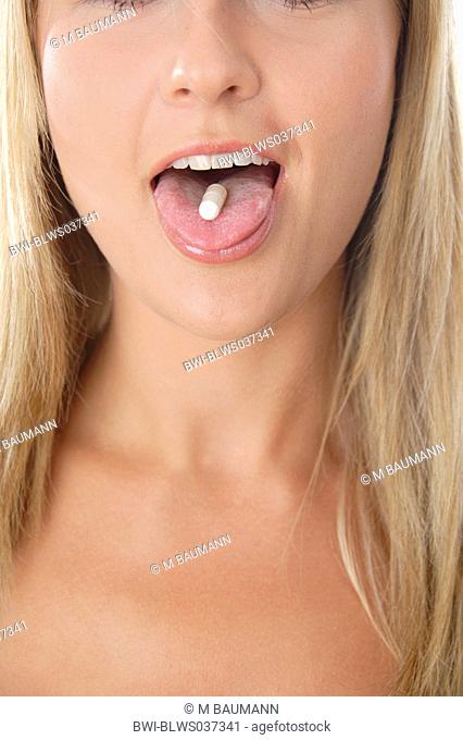 woman with pill on her tongue