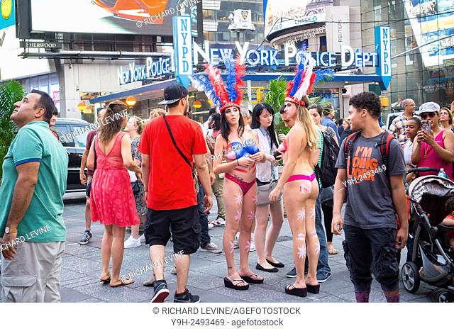Body painted topless women performers solicit tourists in Times Square in New York to pose for photos in exchange for a tip
