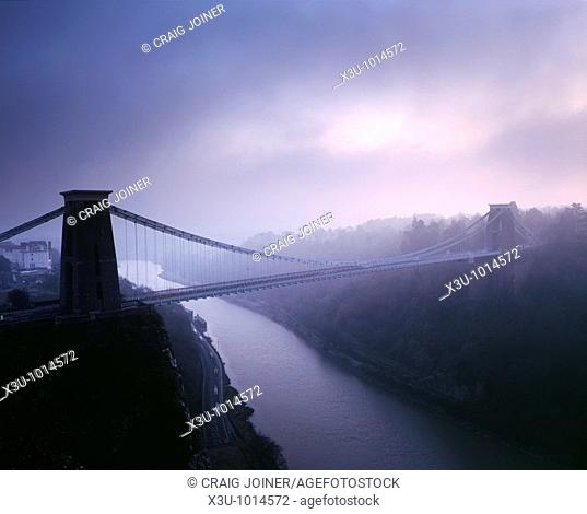 Clifton Suspension Bridge over the River Avon in the Avon Gorge in winter fog just after sunset  Bristol, England, United Kingdom