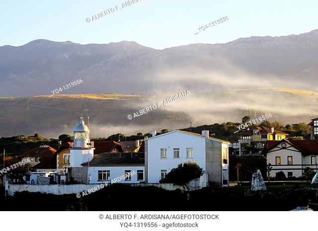 LLanes Lighthouse in a winter day, in the background the Sierra del Cuera, Llanes, Asturias, Spain