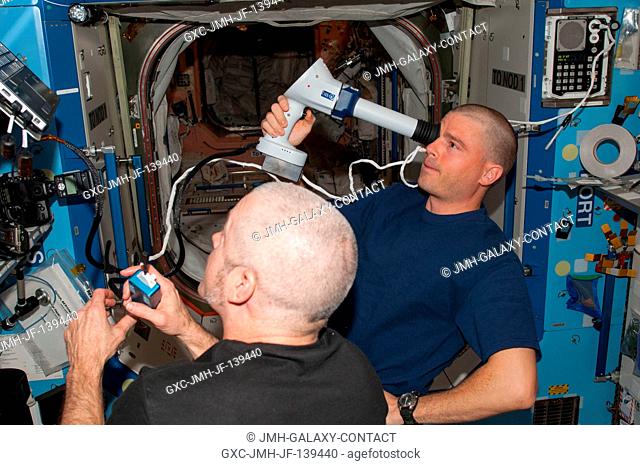 NASA astronaut Reid Wiseman (right), Expedition 40 flight engineer, performs an Ocular Health (OH) examination in the Destiny laboratory of the International...