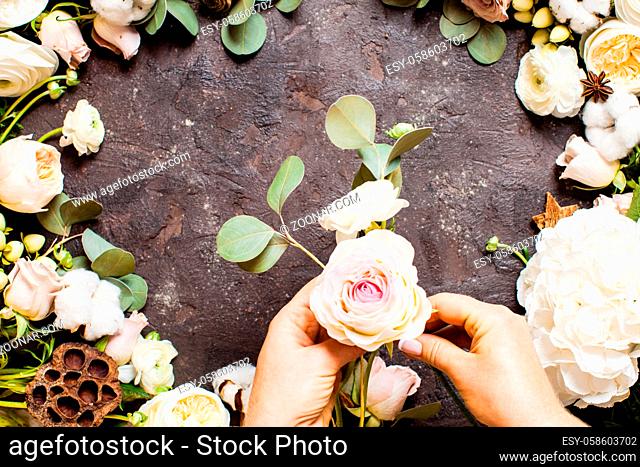 Top view of woman hands with flowers. Florist is making stylish wedding composition, floristic design