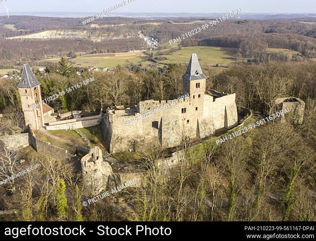 23 February 2021, Hessen, Mühltal: The light of the afternoon sun falls on the walls of Frankenstein Castle (aerial view with a drone)