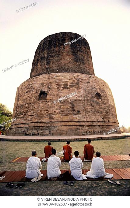 Buddhist monks bowing in prayer ; Sarnath ; Varanasi ; Uttar Pradesh ; India