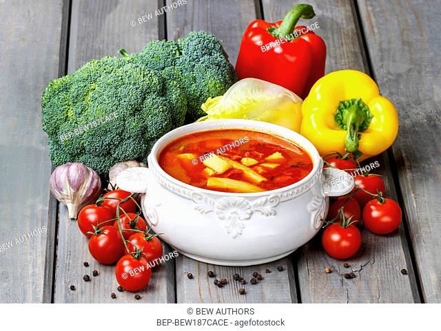 Bowl of tomato soup on wooden table