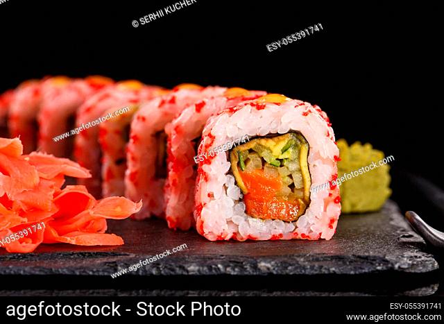 Roll with red caviar of fresh salmon, cream cheese, cucumber, avocado. Served with ginger and wasabi on black ceramic slate. Japanese menu