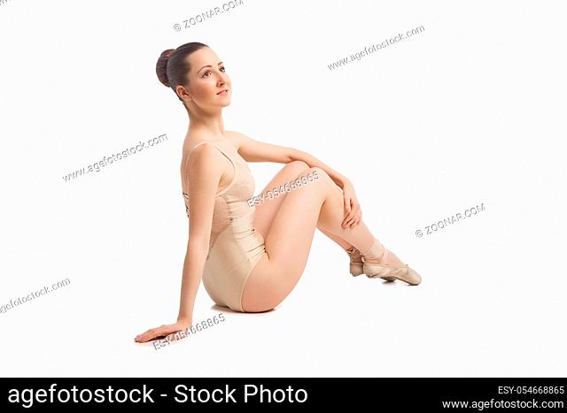 young pretty ballet dancer sitting in elegant pose isolated on white