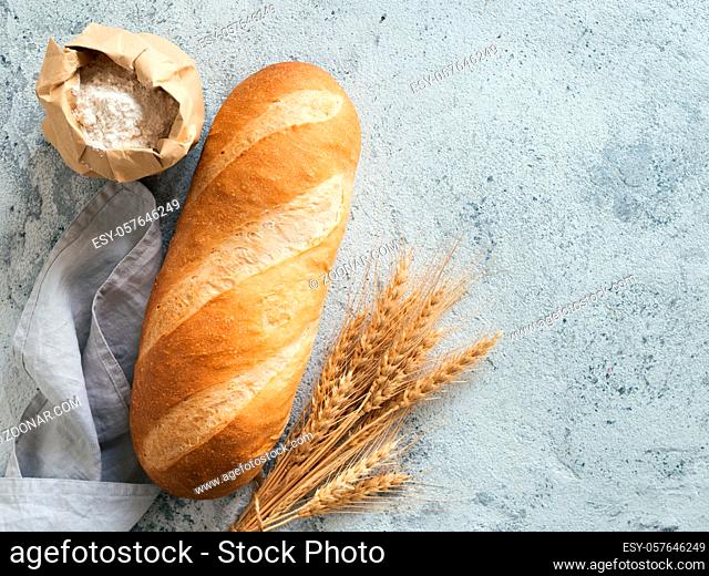 British White Bloomer or European Baton loaf bread on white marble background. Top view or flat lay. Copy space for text or design