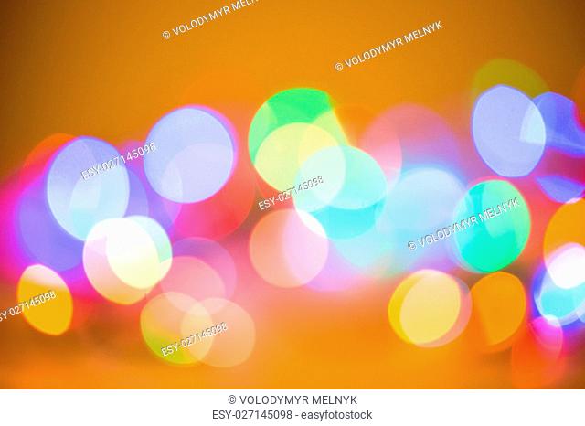 Colorful beautiful blurred bokeh background with copy space. Holiday texture. Glitter multicolored light spots on navy blue backdrop, defocused