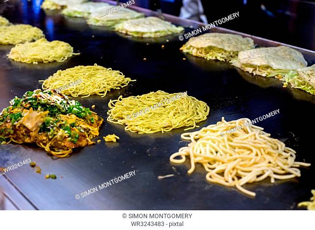 Okonomiyaki being prepared on a large griddle, Hiroshima, Japan, Asia