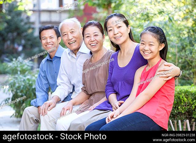 Three Generation Family Sitting in their Apartment Courtyard