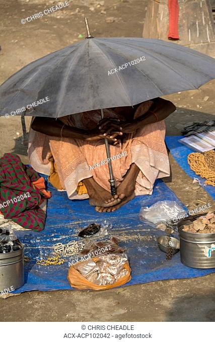 Selling wares under sun umbrella, Haridwar, Uttarakhand, India