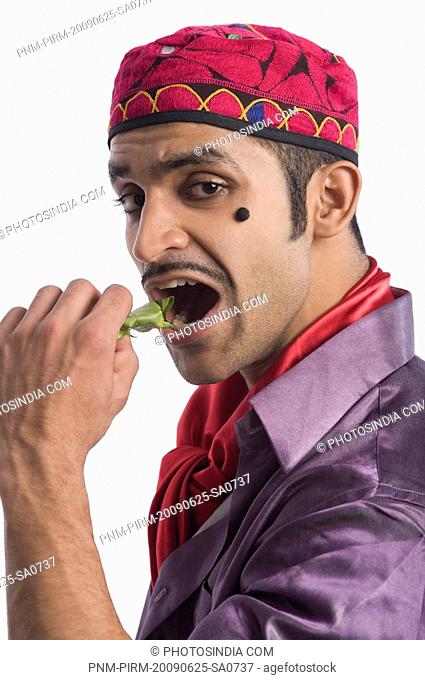 Portrait of an actor portraying a tapori eating pan