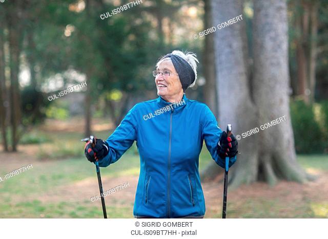 Senior woman nordic walking in park