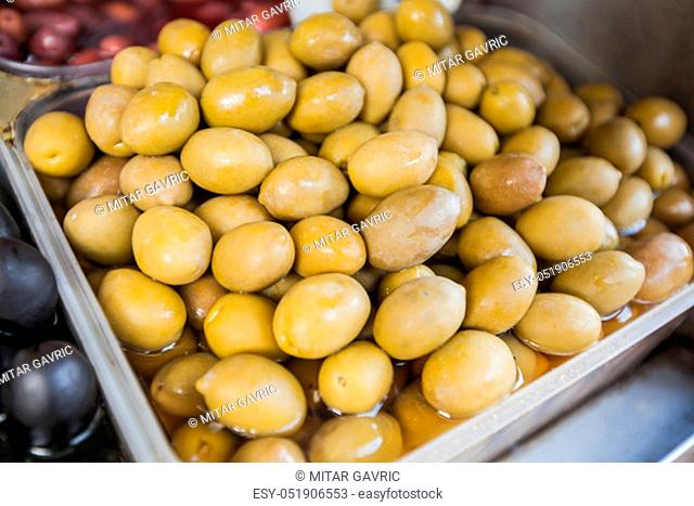 Closeup of fresh healthy green olives for sale at open farmers food market