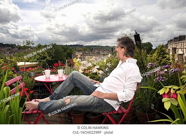 man sitting on balcony
