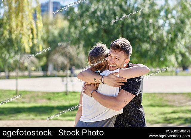 Embracing couple before work out in park