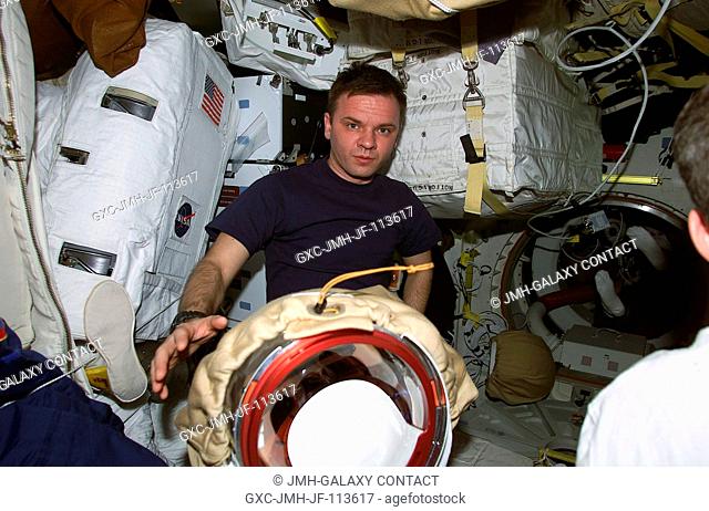 Cosmonaut Yuri P. Gidzenko, now a member of the STS-102 crew, on Discovery's mid deck with extravehicular mobility unit (EMU) space suits