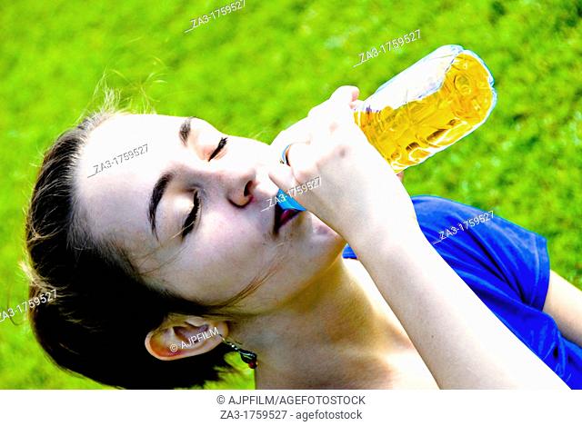 Girl drinking fruit juice in a park