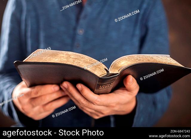 Man reading from the holy bible, close up