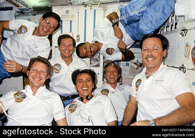The seven crew members for STS-61C mission use the space shuttle Columbia's middeck for the traditional in-flight group portrait during their January 12 - 18