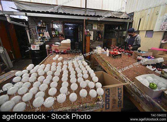 MEXICO CITY, MEXICO - DECEMBER 9, 2020: A worker during the manufacturing of Christmas spheres made with traditional technique of blown glass to decorate the...