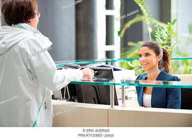 Woman discussing at reception desk