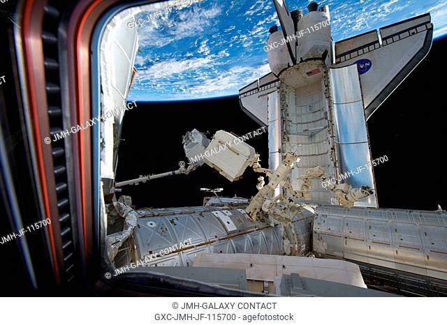In the grasp of the International Space Station's Canadarm2, the Alpha Magnetic Spectrometer-2 (AMS) is transferred from space shuttle Endeavour's payload bay...