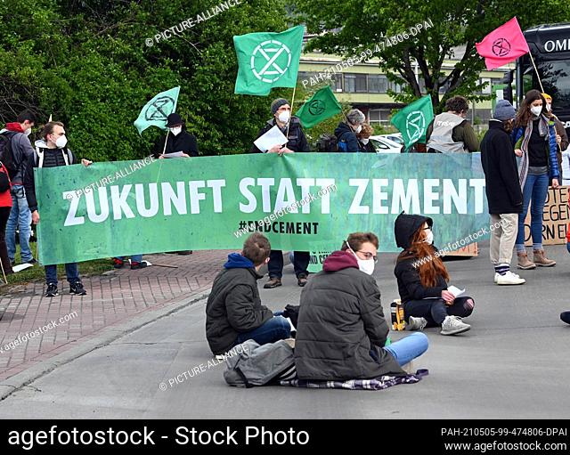05 May 2021, Baden-Wuerttemberg, Leimen: A street blockade takes place in front of a HeidelbergCement cement plant. A banner is displayed that reads ""FUTURE...