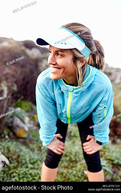 Smiling woman taking break after running