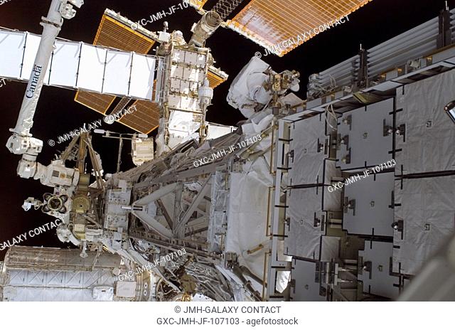 Astronaut Joseph R. Tanner (top center), STS-115 mission specialist, works near the Solar Alpha Rotary Joint (SARJ) during the Sept