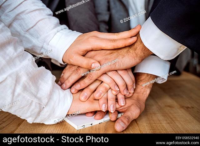 United hands of business team on workspace background. close view