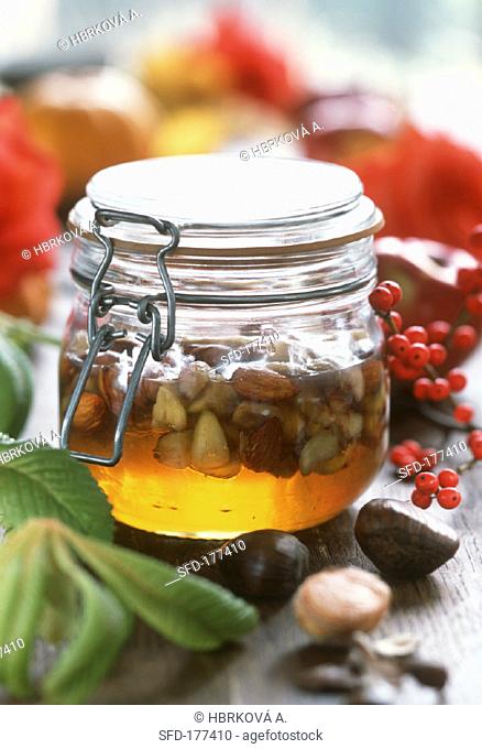 Honey with chestnuts and almonds in jar